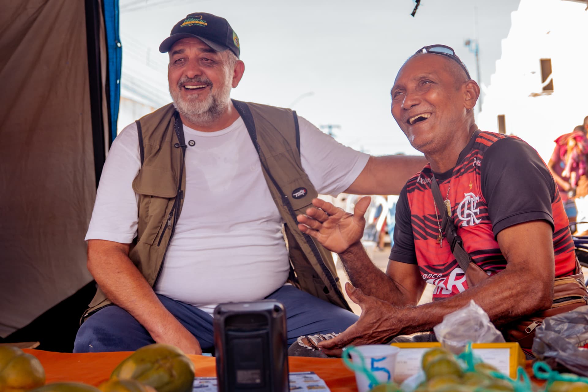 Márcio Junqueira conversando e rindo com um feirante em Roraima